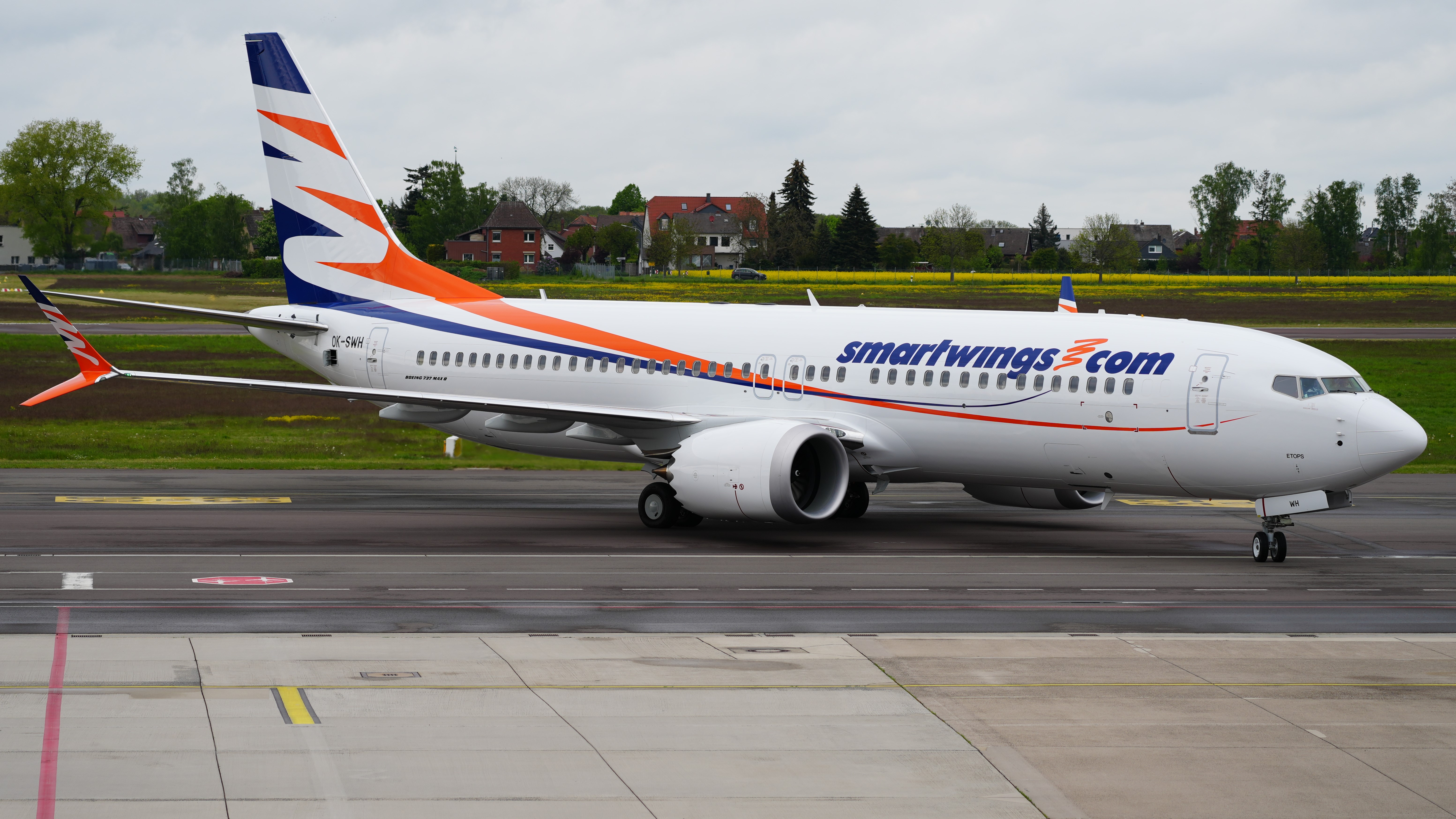A Smartwings Boeing 737-8 MAX aircraft on an airport runway.