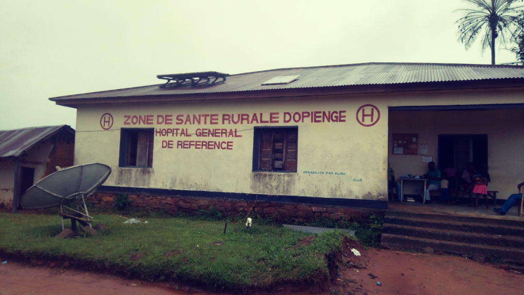 Exterior of the Opienge general referral hospital with a metal roof and painted sign.