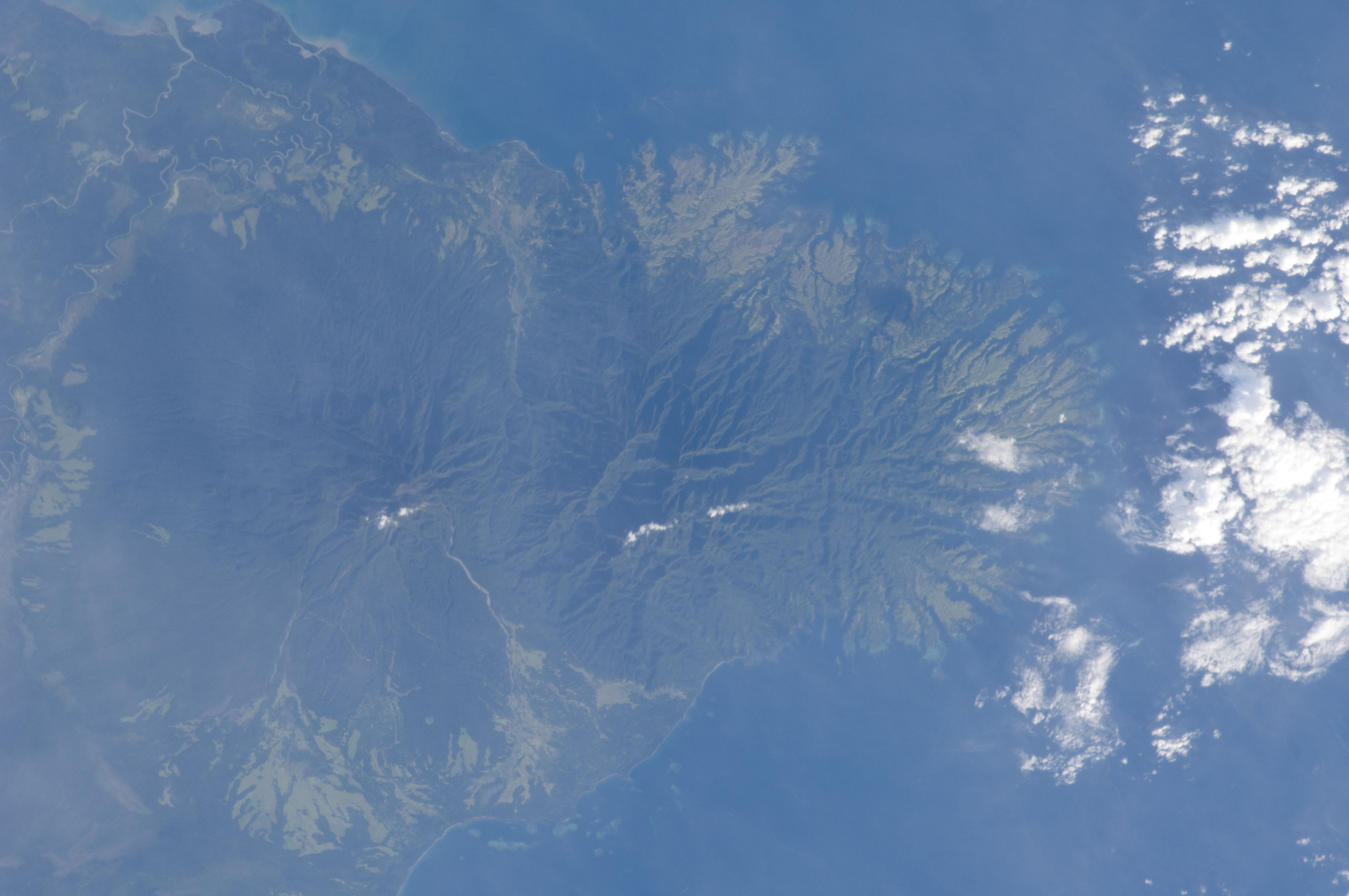 An astronaut photograph of rivers and mountainous terrain in Papua New Guinea.