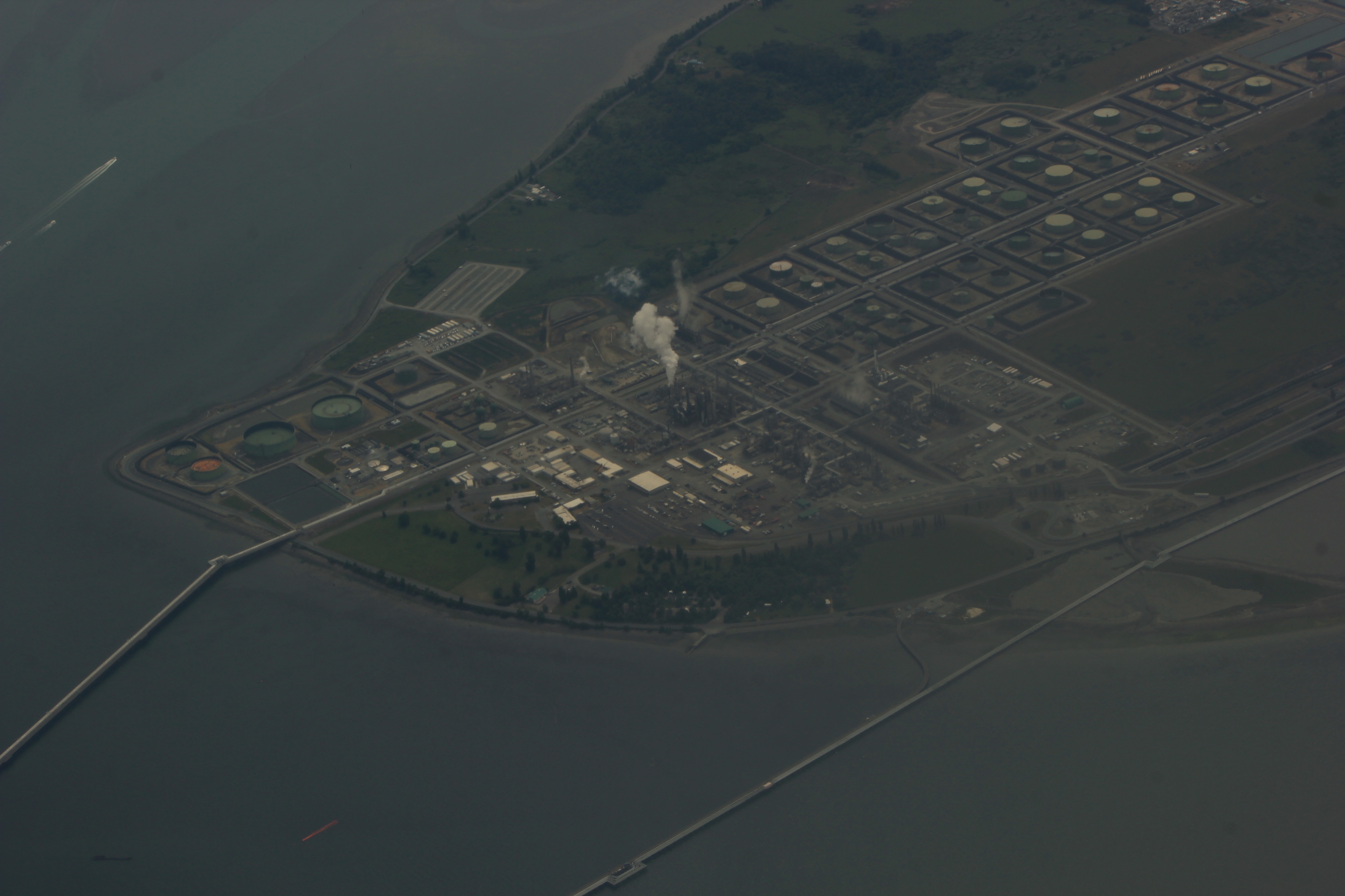 An oil refinery and storage tanks viewed from above.