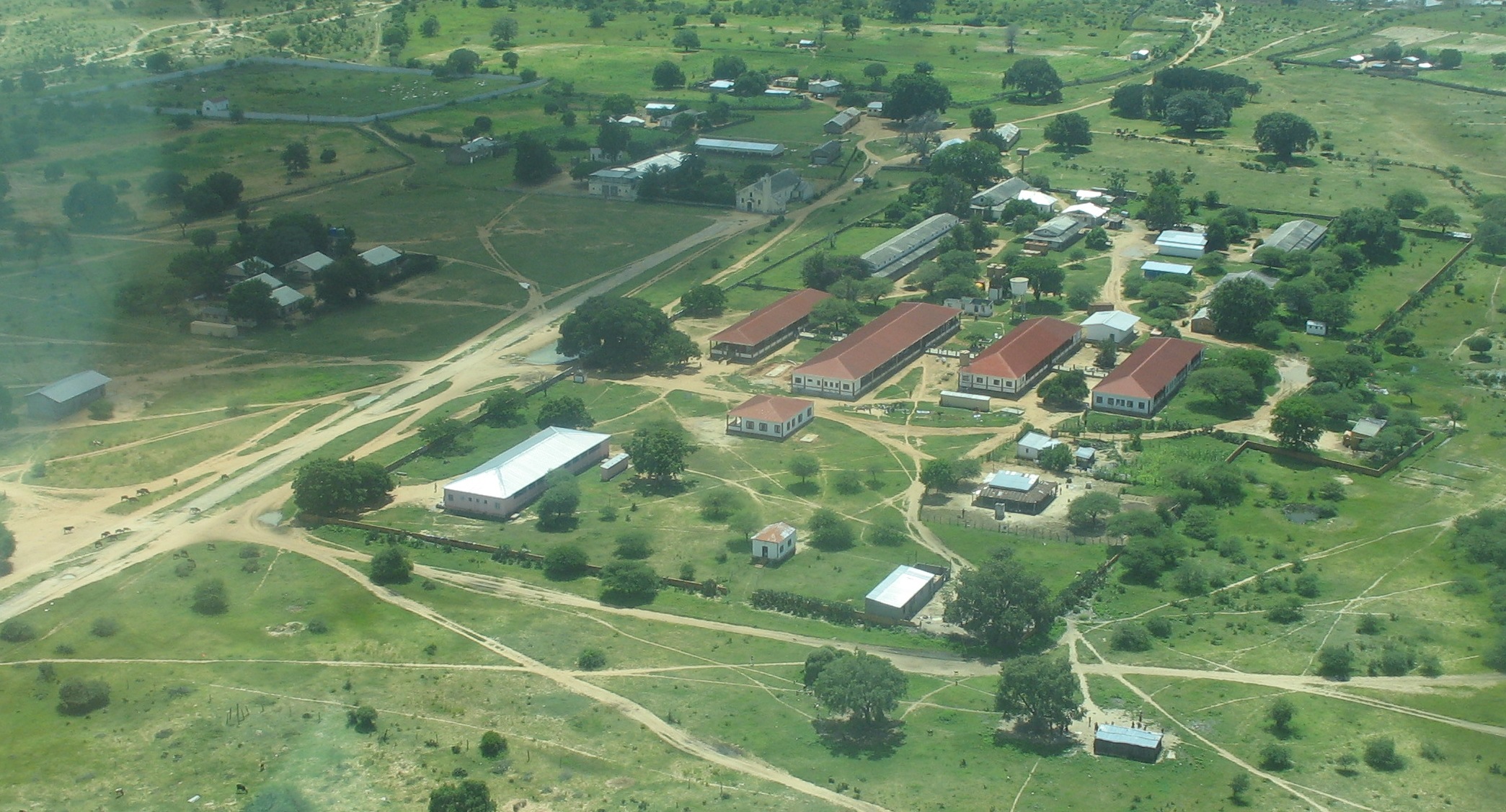 An archive aerial view of buildings, paths and vegetation at Chiulo in Angola.