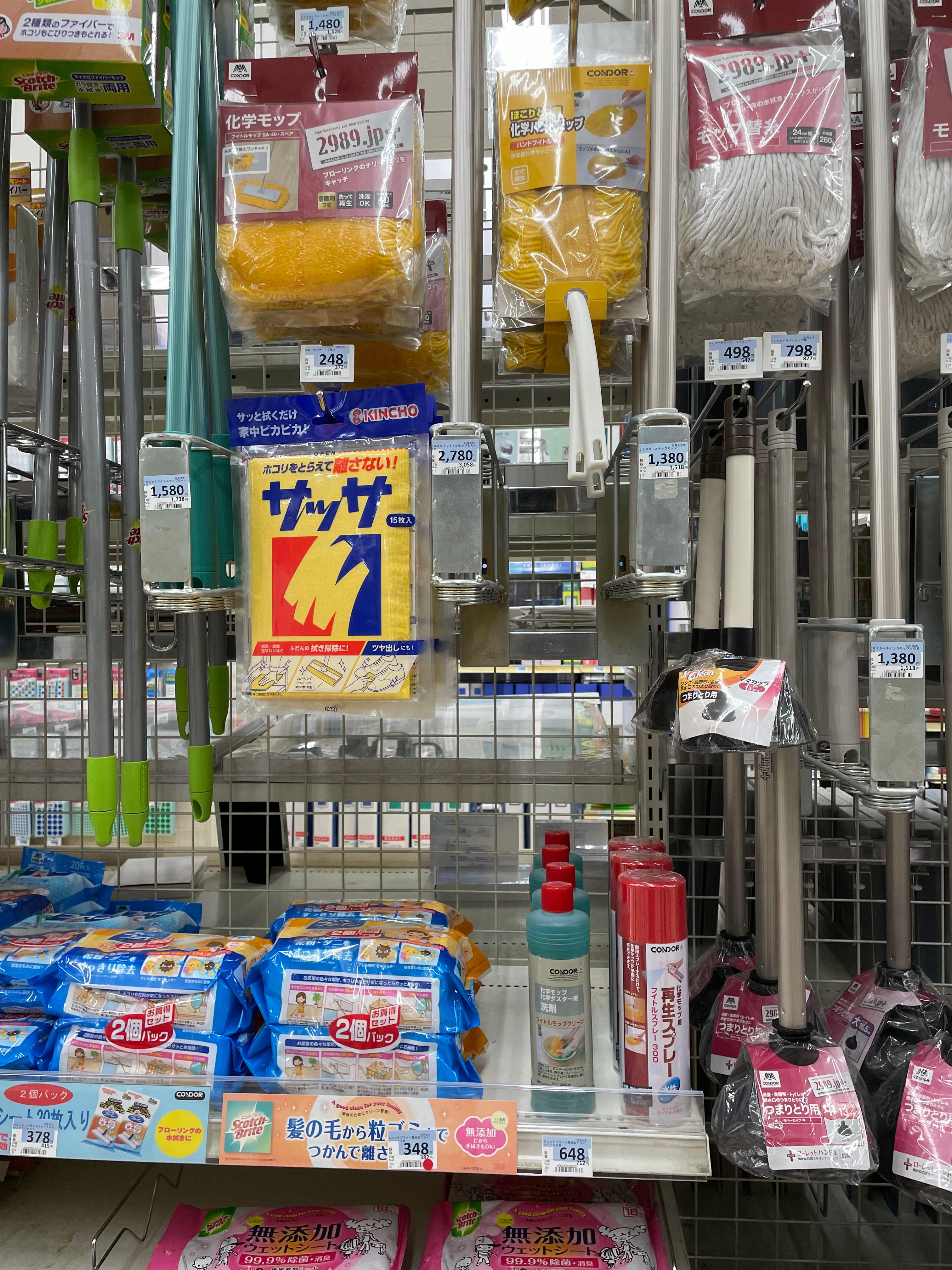 Mops and cleaning supplies displayed in a Japanese hardware store.