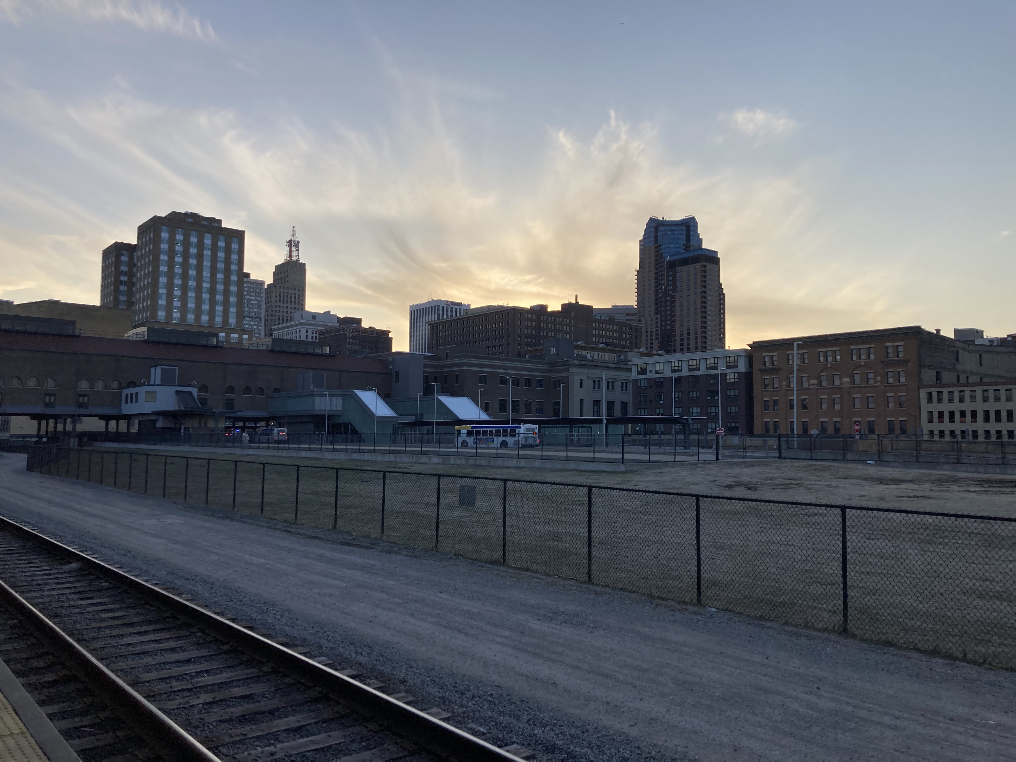 Saint Paul buildings seen across railroad tracks at sunset.