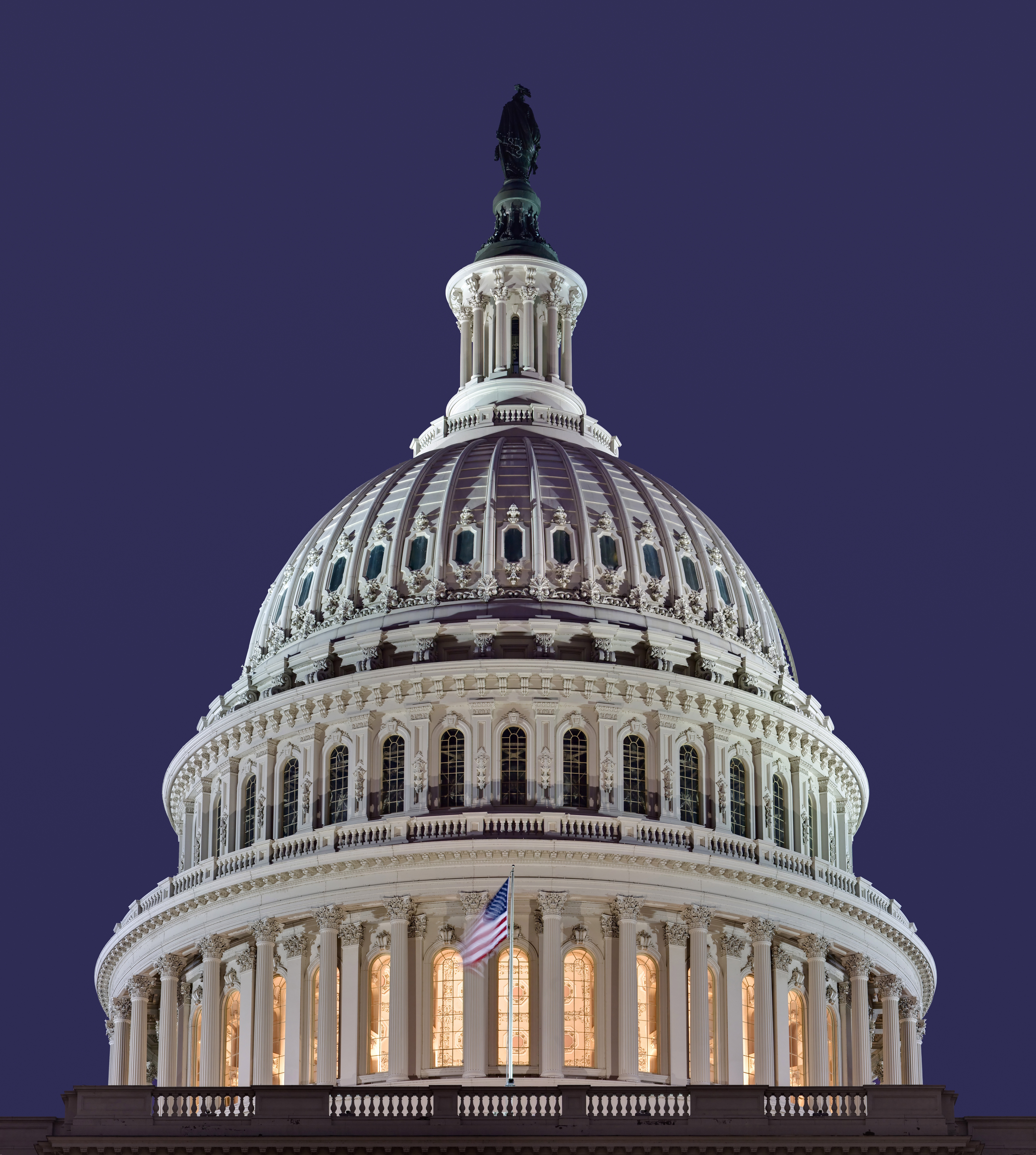 Illuminated U.S. Capitol dome against a dark sky.