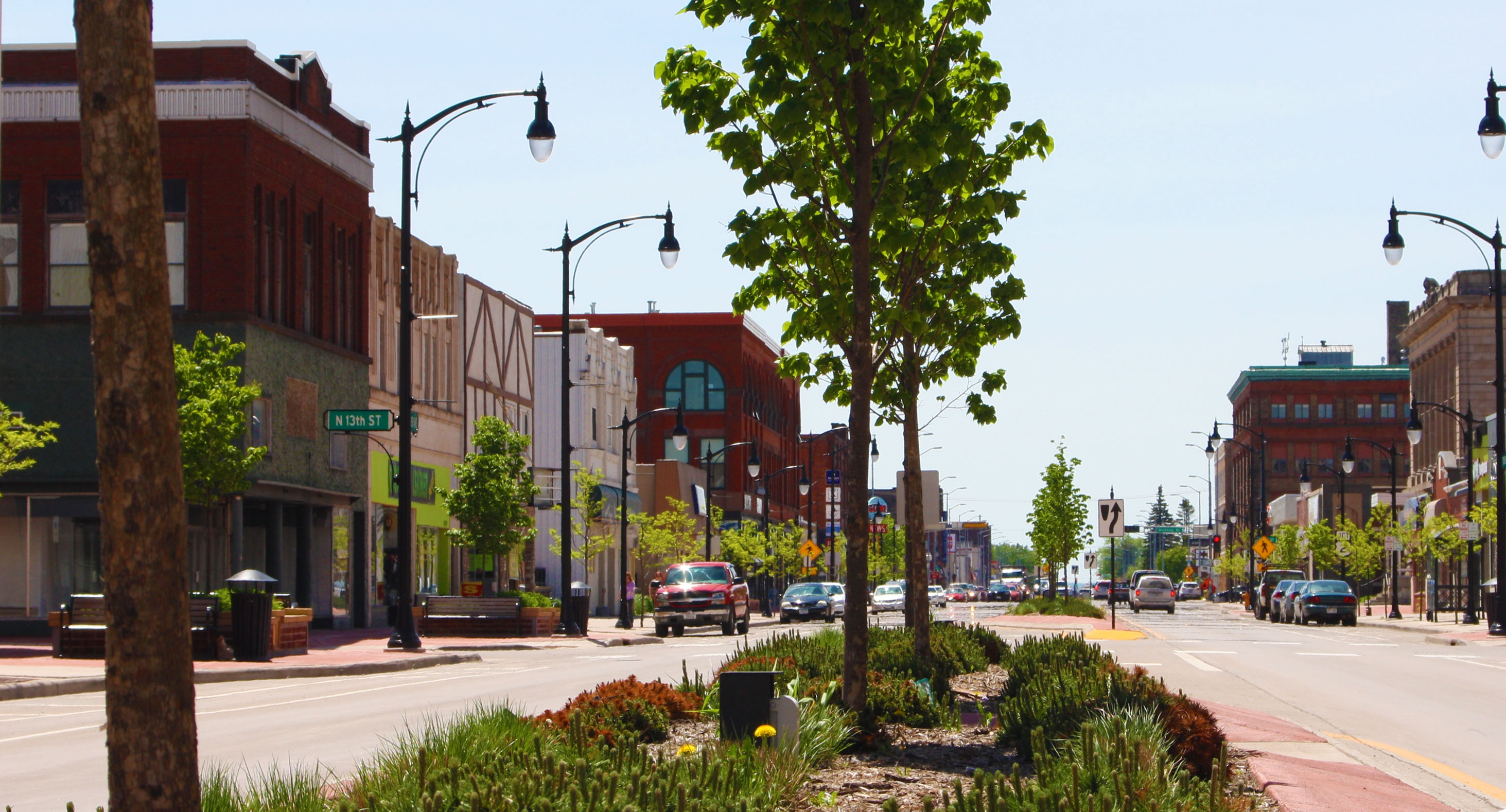 Tree-lined Tower Avenue with shops and cars in Superior.